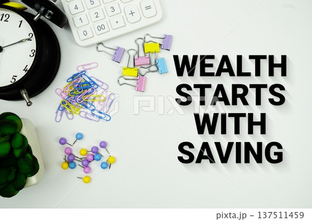 Wealth Starts With Saving message with calculator, alarm clock and Stationery on white background 137511459