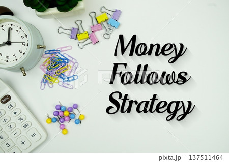 Money Follows Strategy message with calculator, alarm clock and Stationery on white background Money Follows Strategy message with calculator, alarm clock and Stationery on white background 137511464