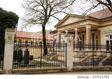 City library building with columns and iron fence in Sombor, Serbia. Cultural institution and historic European architecture concept 137511765