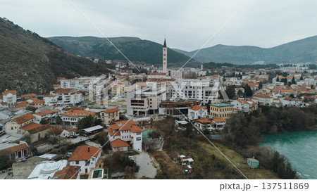 Aerial view of Mostar city with residential neighborhoods, modern buildings, and the turquoise Neretva River framed by surrounding hills in Bosnia and Herzegovina Aerial view of Mostar city with residential neighborhoods, modern buildings, and the turquoise Neretva River framed by surrounding hills in Bosnia and Herzegovina 137511869