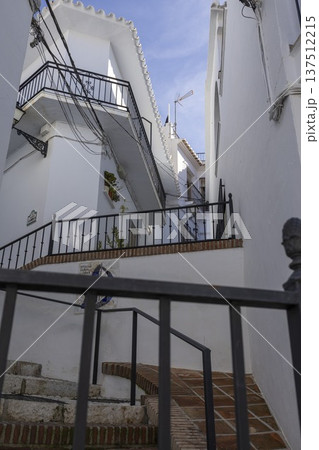 Walking through the narrow streets of Frigiliana, Spain with white houses and stairways on a sunny day Walking through the narrow streets of Frigiliana, Spain with white houses and stairways on a sunny day 137512215