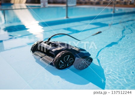Robotic pool cleaner working underwater to keep swimming pool clean. 137512244