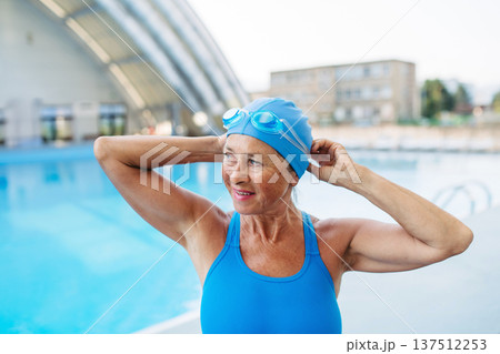 Older female swimmer getting ready for regular fitness swimming. 137512253