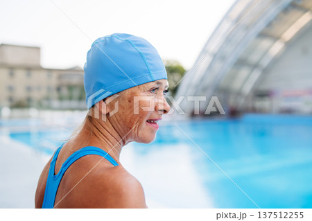 Older female swimmer getting ready for regular fitness swimming. Older female swimmer getting ready for regular fitness swimming. 137512255