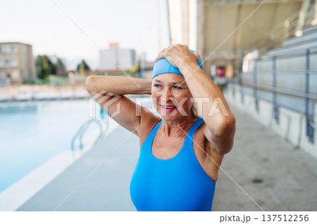 Older female swimmer getting ready for regular fitness swimming. Older female swimmer getting ready for regular fitness swimming. 137512256