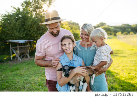 Family petting little goat at farm. 137512265
