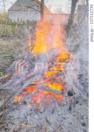 Bonfire made of wood and branches in the garden. Bonfire made of wood and branches in the garden. 137512739