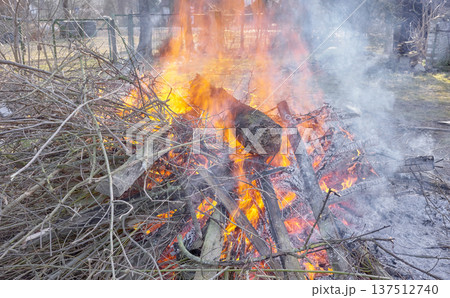 Bonfire made of wood and branches in the garden. Bonfire made of wood and branches in the garden. 137512740