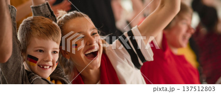 Young German football fans celebrating their team's victory at stadium. 137512803