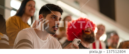 Worried football fans supproting German national team in live soccer match at stadium. 137512804
