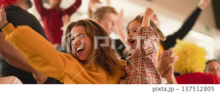 Excited football fans, mother with little daughter, supporting German national team in live soccer match at stadium. 137512805
