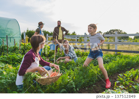 Happy farmers or gardeners working outdoors at community farm. 137512849