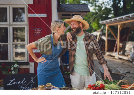 Couple selling fresh organic produce at local farmers market. Couple selling fresh organic produce at local farmers market. 137512851