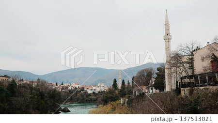 Old town of Mostar with mosque, minaret, historic houses, and turquoise Neretva River. Cultural Balkan cityscape representing history, religion, and travel heritage Old town of Mostar with mosque, minaret, historic houses, and turquoise Neretva River. Cultural Balkan cityscape representing history, religion, and travel heritage 137513021