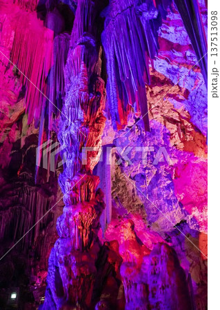 Exploration of the vibrant caves in Gibraltar with impressive rock formations and colorful lighting effects during a guided tour 137513098