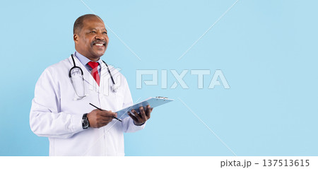 Mature black doctor holding clipboard and writing notes on blue studio background 137513615