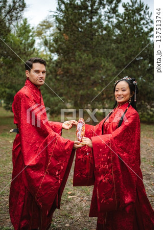 Couple celebrating intercultural wedding in traditional Chinese attire Couple celebrating intercultural wedding in traditional Chinese attire 137513744