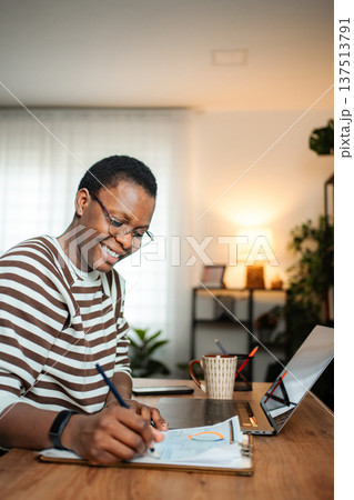 Happy woman working on documents in home office 137513791