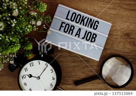 Looking for a Job text in lightbox with magnifying glass and alarm clock flat lay on wooden background Looking for a Job text in lightbox with magnifying glass and alarm clock flat lay on wooden background 137513864