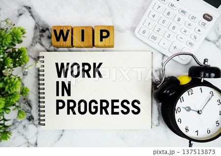 WIP Work In Progress text with calculator and alarm clock on marble background 137513873