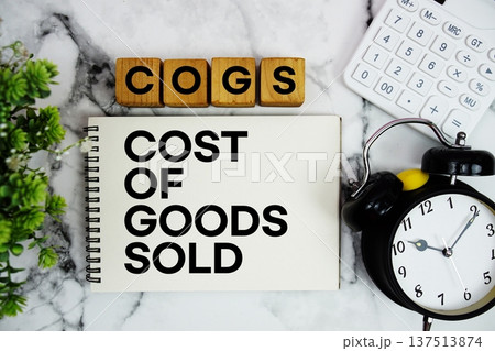 COGS Cost Of Goods Sold text with calculator and alarm clock on marble background 137513874