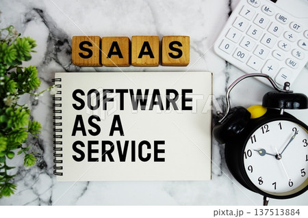 SAAS Software As A Service Is A Software text with calculator and alarm clock on marble background 137513884