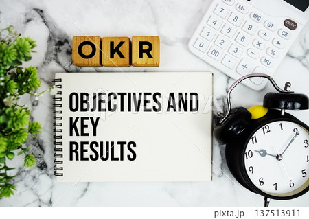 OKR Objectives and Key Results text with calculator and alarm clock on marble background OKR Objectives and Key Results text with calculator and alarm clock on marble background 137513911