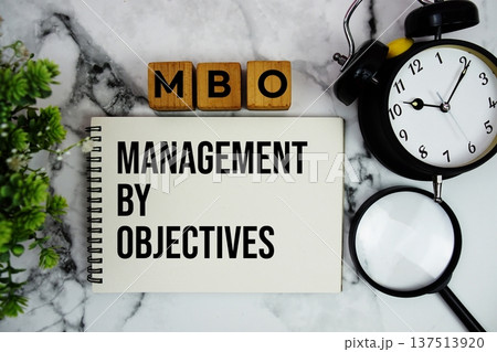 MBO Management By Objectives text with alarm clock and magnifying glass on marble background MBO Management By Objectives text with alarm clock and magnifying glass on marble background 137513920