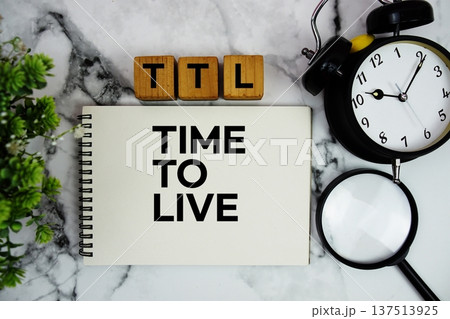 TTL Time To Live text with alarm clock and magnifying glass on marble background TTL Time To Live text with alarm clock and magnifying glass on marble background 137513925