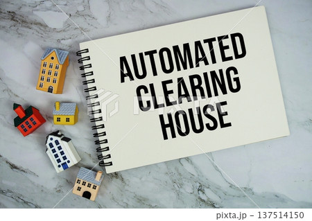 ACH Automated Clearing House text written on notepad with house model on marble background 137514150