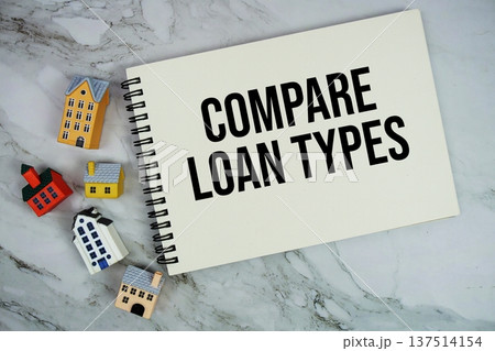 Compare Loan Types text written on notepad with house model on marble background 137514154