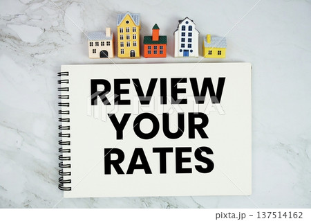 Review Your Rates text written on notepad with house model on marble background 137514162