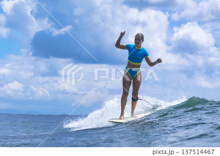 Athletic Female Athlete Standing Firmly Amid Crashing Surf Under Summer Sky Athletic Female Athlete Standing Firmly Amid Crashing Surf Under Summer Sky 137514467