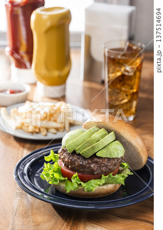 アボカドをのせたハンバーガーとフライドポテトとコーラ 137514694
