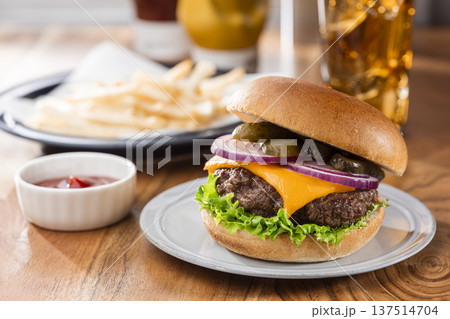 店内テーブルのチーズバーガーとフライドポテトのランチ 137514704