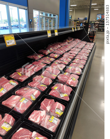 Pork cuts are arranged in a grocery store meat case. Bright price tags and yellow labels sit on the trays. Pork cuts are arranged in a grocery store meat case. Bright price tags and yellow labels sit on the trays. 137514883