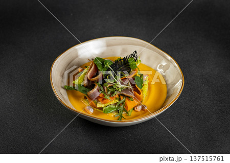 Pumpkin salad with dried duck, cherry tomatoes and pumpkin seeds. Close-up, selective focus 137515761