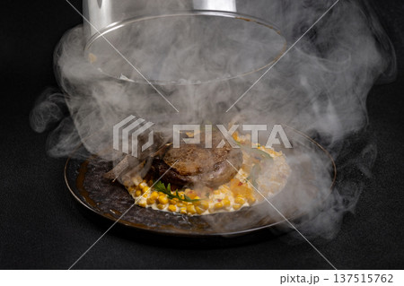 Duck leg with risotto, pumpkin and herbs on a dark background 137515762