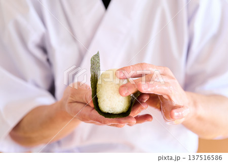 おにぎりに海苔を巻く料理人 137516586