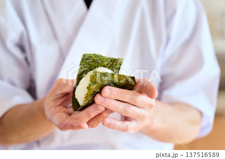 おにぎりに海苔を巻く料理人 137516589