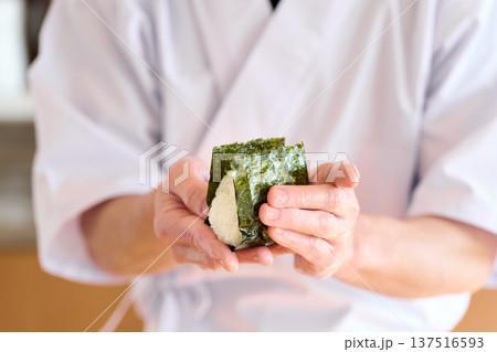 おにぎりに海苔を巻く料理人 137516593