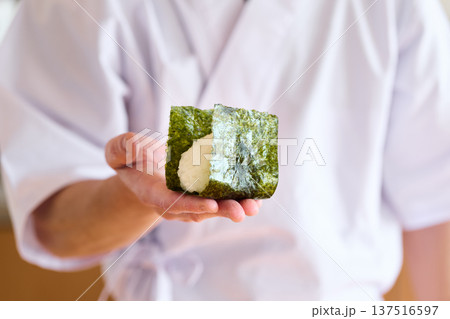 おにぎりに海苔を巻く料理人 137516597