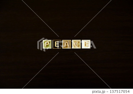 ダークウッドの背景に並んだ「PEACE」の文字タイル 137517054