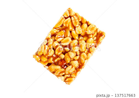 A piece of Brazilian peanut brittle made with roasted peanuts and shiny caramel, isolated on a white background. A typical Brazilian sweet A piece of Brazilian peanut brittle made with roasted peanuts and shiny caramel, isolated on a white background. A typical Brazilian sweet 137517663