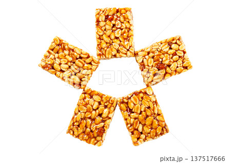 Five pieces of peanut brittle Brazilian peanut candy, made with caramelized peanuts, arranged in a circular shape and isolated on a white background. A traditional Brazilian sweet 137517666