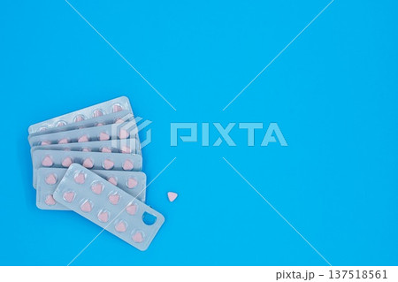 Medication Triangle Pink Pills in Aluminum Foil Packaging Blue Background Copy Space top And Right Side Medication Triangle Pink Pills in Aluminum Foil Packaging Blue Background Copy Space top And Right Side 137518561