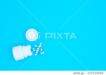 Medication White and Blue Pills and Container Blue Background Copy Space Top Right Side Medication White and Blue Pills and Container Blue Background Copy Space Top Right Side 137518568