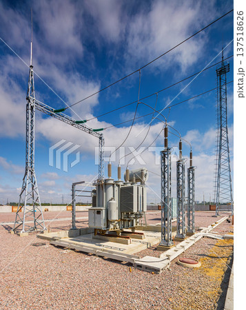 Vertical view of an outdoor electrical distribution substation, without people, at daytime on a background of a clear blue sky 137518626