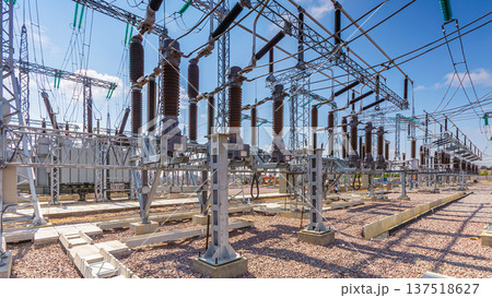Panoramic view of an outdoor electrical distribution substation, without people, at daytime on a background of a clear blue sky Panoramic view of an outdoor electrical distribution substation, without people, at daytime on a background of a clear blue sky 137518627