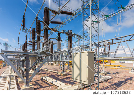 Panoramic view of an outdoor electrical distribution substation, without people, at daytime on a background of a clear blue sky Panoramic view of an outdoor electrical distribution substation, without people, at daytime on a background of a clear blue sky 137518628